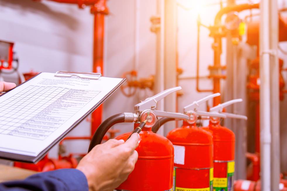 a person is inspecting the fire extinguishers